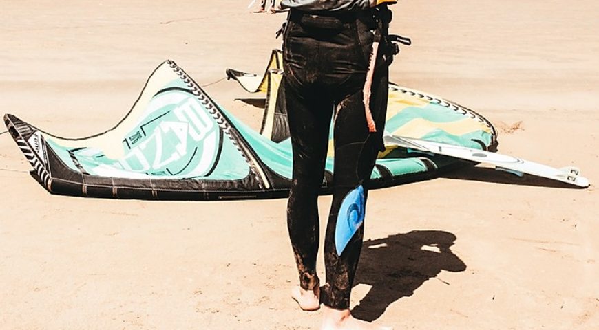 homme-kitesurfer-pose-sa-voile-sur-le-sable